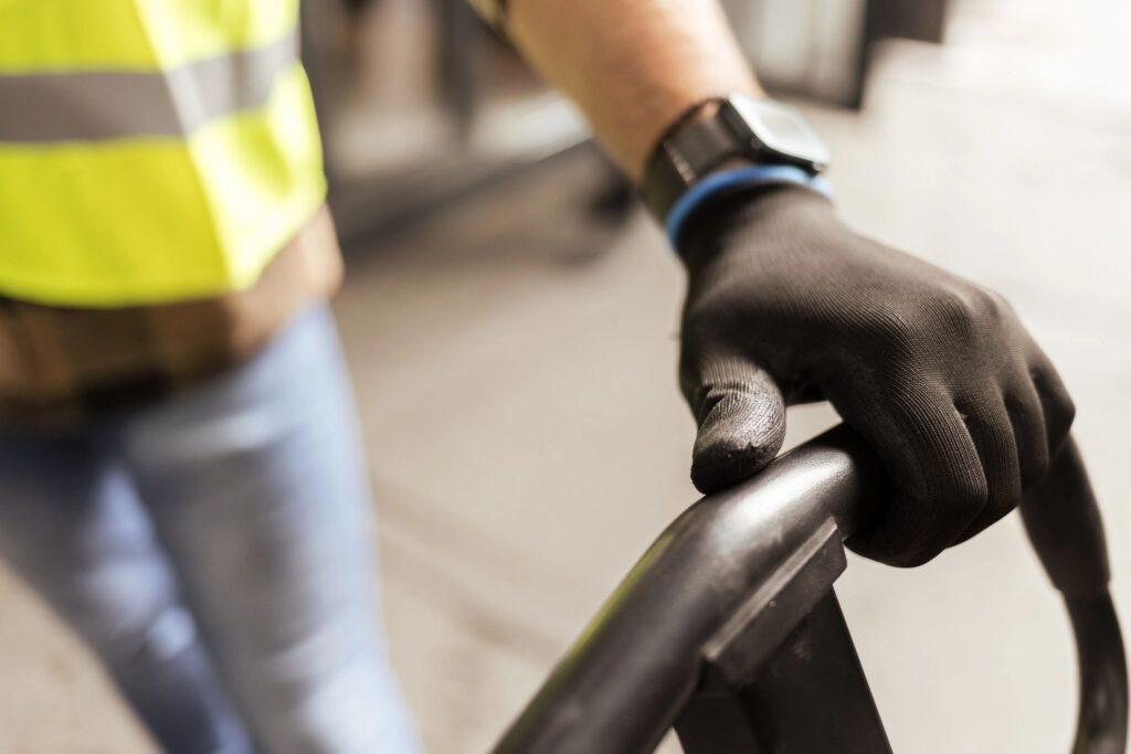 Close-up of worker hands operating pallet jack